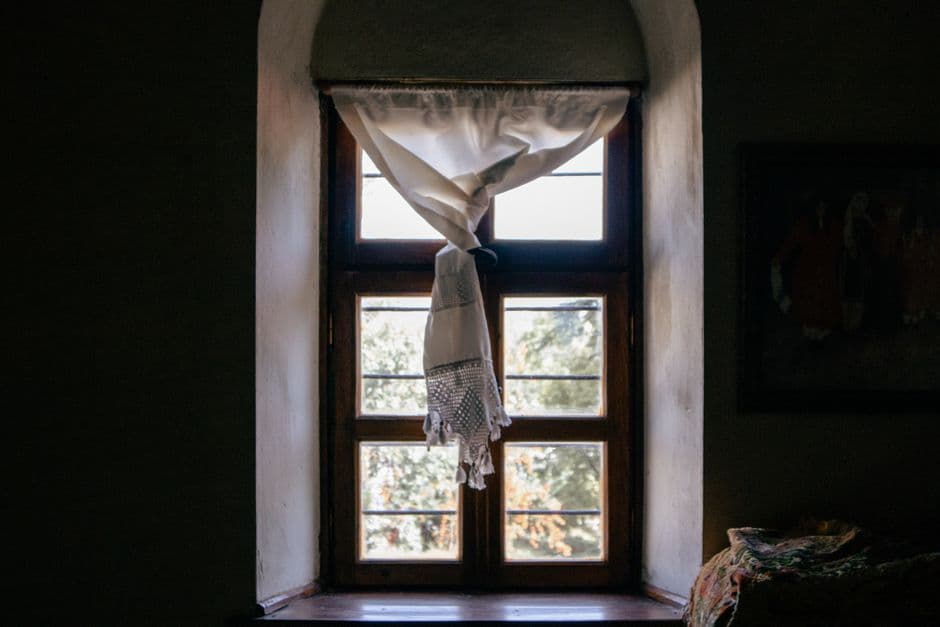 Charming window with sunlight streaming through vintage curtains in Elazığ, Türkiye.